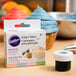A box of Wilton Pastel Gel Food Coloring next to a cupcake.