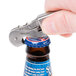 A hand using a Franmara Duo-Lever Waiter's Corkscrew to open a bottle of beer with a blue cap.