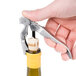 A hand using a Franmara Duo-Lever Waiter's Corkscrew to open a bottle of wine.