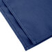 A folded royal blue Intedge cloth napkin.