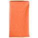An orange folded Intedge cloth napkin.