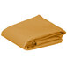 A folded gold rectangular cloth table cover.