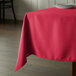 An Intedge hot pink square tablecloth on a table.