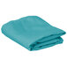 A folded teal rectangular cloth table cover on a white background.