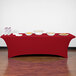 A crimson Snap Drape spandex table cover on a table with food.