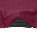 A close up of a burgundy Snap Drape spandex table cover corner.