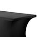 A black Snap Drape spandex table cover with a curved edge on a table.
