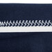 A close up of a navy blue fabric zipper with white stitching.