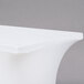 A white Snap Drape spandex table cover on a table with a white surface.