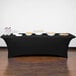 A black Snap Drape spandex table cover on a table with food.