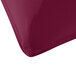 A corner of a burgundy Snap Drape Contour Table Cover on a table.