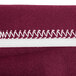 A burgundy spandex table cover with maroon and white striped packaging.