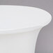 A white Snap Drape contour table cover on a round table with a white surface.