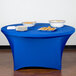A royal blue Snap Drape spandex table cover on a table with plates of food.