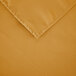 A white 54" x 54" square gold polyester table cover with hemmed edges.