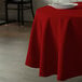 A red Intedge round tablecloth on a table.