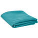 A folded teal blue Intedge table cover on a white background.