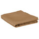 A folded tan Intedge square table cover.