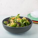 A close up of a Fiesta Slate China Bistro Bowl filled with salad.