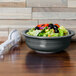 A Fiesta Slate china serving bowl filled with salad with olives and tomatoes.