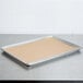 A Baker's Mark unbleached Quilon-coated parchment paper sheet on a baking tray with a brown substance.