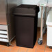 A brown Continental Swingline square trash can with a lid sitting in a kitchen.