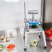 A Nemco Easy Chopper III vegetable dicer on a stainless steel counter full of diced tomatoes.