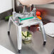 A person using a Nemco Easy Chopper III to dice vegetables on a counter.