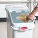 A clear plastic Rubbermaid ingredient bin lid with a scoop hook on it, holding pasta.
