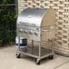 A stainless steel Backyard Pro roll dome lid on a grill with knobs and handles.