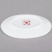 A bright white porcelain plate with a red circle on it.