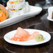 A 10 Strawberry Street bright white porcelain plate with a salmon sushi roll on it.