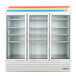 A white True refrigerated glass door merchandiser with shelves.