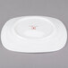 A white porcelain square side plate with a red ripples logo.