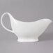 A white porcelain gravy boat with a gray background.