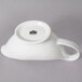 A white porcelain gravy boat with a handle and a spout.
