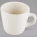 A Tuxton eggshell white tall china cup with a handle.