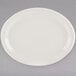 A white Tuxton oval china platter with a narrow rim on a gray surface.