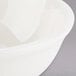 A Tuxton eggshell china nappie bowl with a white rim.