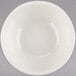 A white Tuxton Reno china bowl on a gray surface.