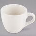 A Tuxton eggshell white china espresso cup with a handle.