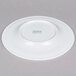 An Arcoroc white porcelain brunch plate with green writing that says "Arc Cardinal" in green.