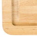 A Tablecraft wood grooved cutting board with non-slip legs.
