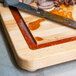 A knife on a Tablecraft wood cutting board.
