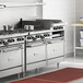 A stainless steel Garland commercial gas range with 2 ovens and a raised griddle.