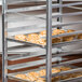 A Channel end load sheet pan rack holding trays of pastries.