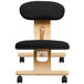 A black Flash Furniture kneeling office chair with wooden frame and wheels.