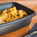 A black Genpak Smart-Set Pro rectangular container with rice and corn in it.