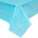 A Bermuda Blue plastic tablecloth on a table with a blue background.