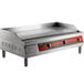 An Avantco stainless steel countertop electric griddle with red handles.